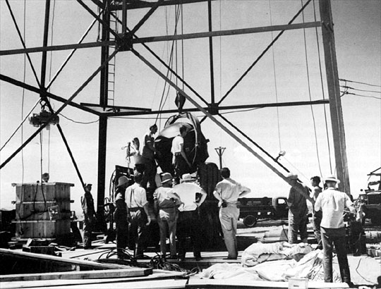 Bomb being hoisted on its
                  tower